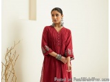 The image shows a young woman wearing a red kurta with intricate embroidery on the sleeves and hem. The dress has a V-necklin...