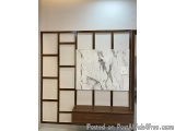 The image shows a modern wall-mounted entertainment center with a wooden frame and a white marble panel. The panel is divided...