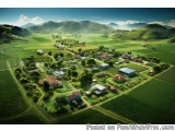 The image is an aerial view of a small town or village nestled in a valley surrounded by green fields and mountains. The town...