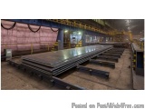The image shows a large warehouse with a conveyor belt running through it. The warehouse appears to be a large industrial spa...