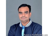 The image is a professional headshot of a man. He is facing the camera with a neutral expression on his face. He has short da...
