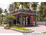 The image shows a colorful temple with a gazebo in the center. The temple is decorated with intricate designs and patterns in...