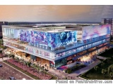 The image is an aerial view of a modern building with a unique architectural design. The building is located in an urban area...