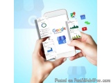 The image shows a pair of hands holding a smartphone with the Google My Business app open on the screen. The app has a blue b...