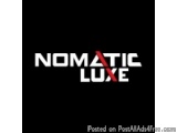 The image is a black background with the text "NOMATIC LUXE" written in white capital letters. The text is in a bold, sans-se...