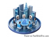 The image shows a group of six people sitting around a round conference table in a meeting room. The table is in the center o...