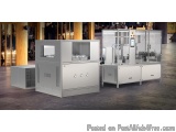 The image shows a large industrial machine in a warehouse or factory setting. The machine is made of stainless steel and has...