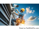 The image shows a construction worker wearing a yellow hard hat and a tool belt with various tools in it. He is standing on a...