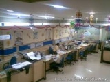 The image shows an office space with multiple desks and chairs arranged in neat rows. The desks are covered with papers and o...