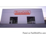 The image shows a large white building with a red sign that reads "Stonefields" on the top. The building appears to be a ware...