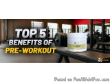 The image shows a white jar of pre-workout supplement on a black bench in a gym. The jar has a yellow label with the brand na...