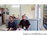 The image shows a group of people sitting in front of a glass door with a sign that reads "Push to a new SAP Gurgaon Program"...