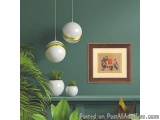 The image shows a corner of a room with green walls. On the right side of the image, there is a framed picture hanging on the...