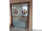 The image shows a glass door with a wooden frame. The door is made of glass and has a handle on the right side. On the glass,...