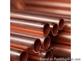The image shows a group of copper pipes stacked on top of each other. The pipes are of different sizes and lengths, with some...