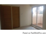 The image shows an empty room with a sliding glass door on the right side. The door is made of wood and has a handle on the l...
