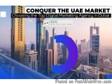 The image shows a cityscape of Dubai, United Arab Emirates, with tall buildings and skyscrapers. The sky is blue and the sun...