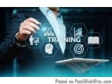 The image shows a man in a suit holding a tablet with the word "TRAINING" written on it. The background is blurred, but it ap...
