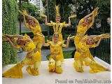 The image shows a group of six dancers performing a dance routine. They are all wearing matching yellow costumes with intrica...