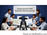 The image shows a group of people gathered around a desk in front of multiple computer monitors. They are all looking at a ma...