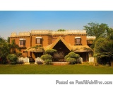 The image shows a beautiful two-story house with a unique architectural design. The house is made of terracotta tiles and has...