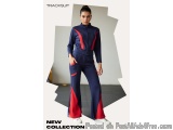 The image shows a young woman wearing a tracksuit. The tracksuit is navy blue with red accents on the sides and back. The jac...