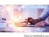 The image shows a person's hands typing on a laptop keyboard. The laptop is placed on a desk with various office supplies sca...