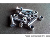 The image shows a collection of screws and nuts scattered on a black surface. There are nine screws in total, with six of the...