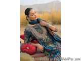 The image shows a young woman sitting on a bench in a field. She is wearing a traditional Pakistani outfit with a blue and gr...
