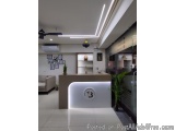 The image shows the interior of a modern office lobby. The lobby has a white reception desk with a logo on the front that rea...