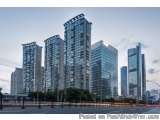 The image shows a group of tall, modern skyscrapers in a city. The buildings are made of glass and steel, and they are arrang...