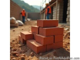 The image shows a stack of red bricks on a construction site. The bricks are stacked on top of each other and are arranged in...