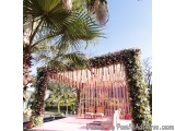 The image shows a beautiful outdoor wedding ceremony setup. The focal point of the image is a large arch decorated with pink...