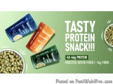 The image is an advertisement for a tasty protein snack. It has a green background with three packets of protein in different...