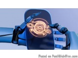 The image shows a close-up of a robotic arm with a blue background. The arm is holding a black object with a circular design...