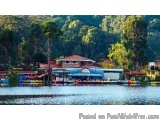 The image shows a beautiful landscape of a lake with a red-roofed building on the right side. The building appears to be a re...