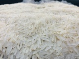 The image is a close-up of a pile of white rice. The rice appears to be uncooked and has a grainy texture. The grains are arr...
