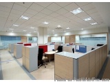 The image shows an empty office space with multiple cubicles arranged in a row. The cubicles are made of wood and have a mode...