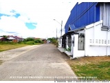 The image shows a street view of a residential area with a blue building on the right side. The building has a white exterior...