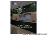 The image shows a modern kitchen with dark green cabinets and white countertops. The kitchen has a large island with a sink a...