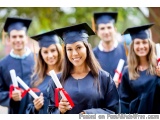 The image shows a group of six young graduates, all wearing blue graduation gowns and caps, standing in a line and holding th...
