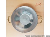 The image shows a round, silver-colored metal bowl with two handles on either side. The bowl appears to be made of stainless...