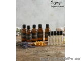 The image shows a group of small glass bottles with black caps arranged on a wooden surface. The bottles are labeled with the...