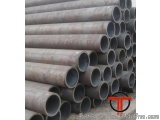 The image shows a stack of steel pipes stacked on top of each other. The pipes are cylindrical in shape and appear to be made...