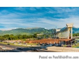 The image is a landscape photograph of a large building with a unique architectural design. The building appears to be a temp...