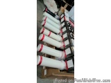 The image shows a stack of white cylindrical pipes with red stripes on them. The pipes are arranged in a neat stack and are s...