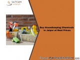 The image shows a white basket filled with various cleaning supplies. The basket is placed on a tiled floor in front of a bri...