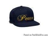 The image is of a navy blue baseball cap with the word "Peace" written in gold cursive font in the center. The cap has a curv...