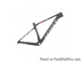 The image is a 3D rendering of a Scott mountain bike frame. The frame is black with the word "SCOTT" written in white and red...