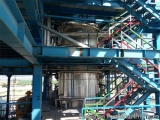 The image shows a large industrial structure with a blue metal structure and stairs leading up to it. The structure appears t...
